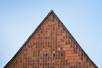 Ein mit Dachziegeln aus Ton verkleideter Giebel an einem Haus