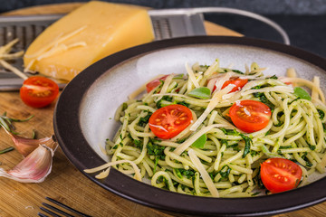 Pasta with spinach, tomatoes and cheese on plate
