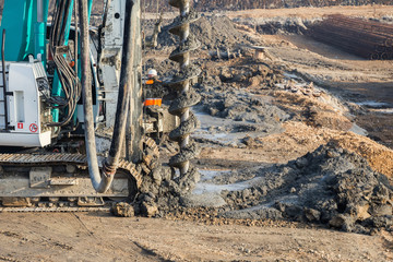 Drilling tractor installs concrete piles
