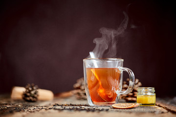 Dampfender Tee und Honig auf einem Holztisch