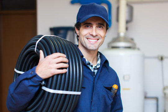 Portrait of a smiling worker carrying corrugated conduit
