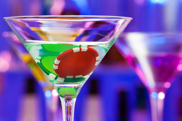 Two casino chips in the bar cocktail glass
