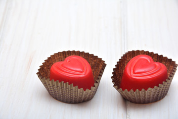 Heart-shaped chocolates on the white background 