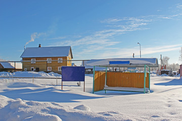 Naklejka premium Swept snow bus stop in the cold winter