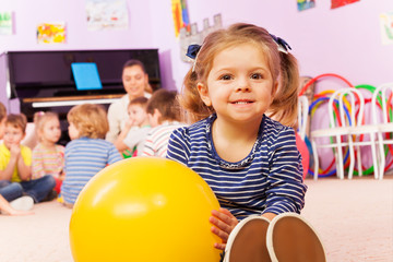 Little girl with ball sit in developmental class 