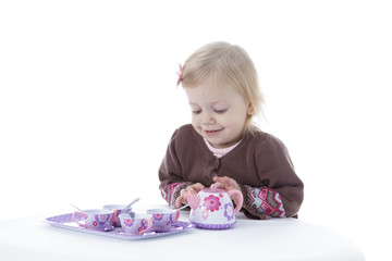 toddler girl playing with tea set, isolated on white background