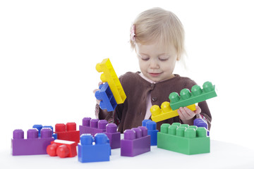 toddler girl playing with tea set, isolated on white background