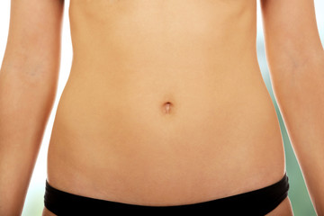Fototapeta na wymiar Fit and slim young woman belly.