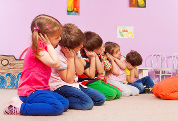 Group of kids in kindergarten pretend to sleep