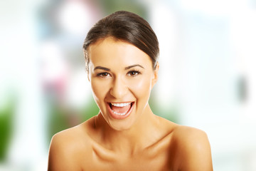 Portrait of nude woman laughing loud