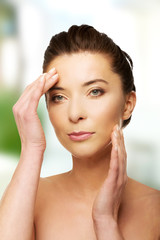 Naklejka premium Spa woman with make up touching her face.