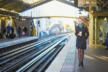 Fototapeta premium Beautiful young woman waiting for a train in Parisian underground