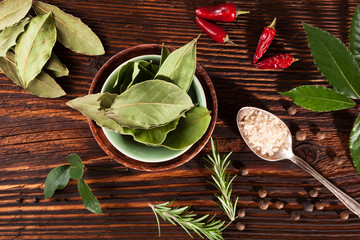 Spice and condiments wooden background.