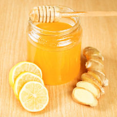 Folk remedies for colds honey, lemon, ginger root on a wooden surface