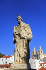 Obraz premium Statue of Saint Vicente de Fora in Lisbon and house roofs