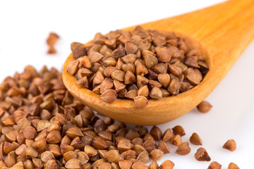 Uncooked buckwheat on wooden spoon