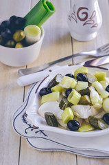 Warm Salad with dried cod, leek, almonds on a plate in the shape of a fish 