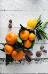 tangerines and lemons with leaves on a wooden background