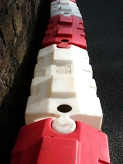 Red and white mobile plastic water-filled jersey barriers for a temporary roadblock
