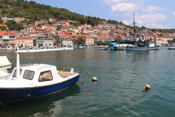 Small boats in the port of Vela Luka, on Korcula island, Croatia. Vela Luka and big fishing boat in the backgound. Selective focus.