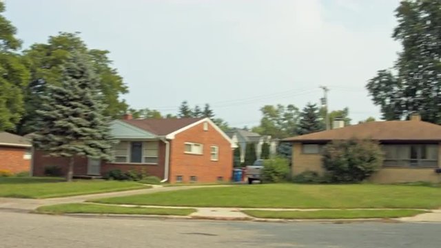 Driving plate: rear view, 1950s-70s single-storey, ranch-style houses in Mid West US neighborhood.  Intended for compositing.  24mm lens, stabilized clip, moderate speed