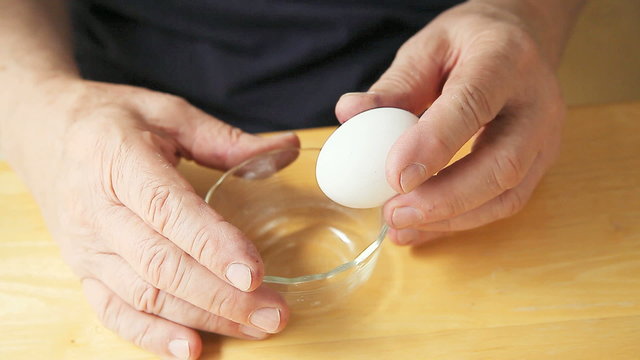 Man with finger tremor separates egg