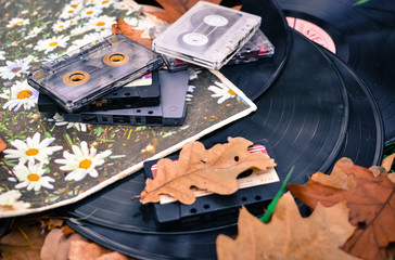 Old cassettes and records with fallen leaves