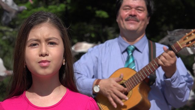 Father and Daughter Singing and Playing Guitar