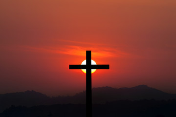 Silhouette of cross over sunset background