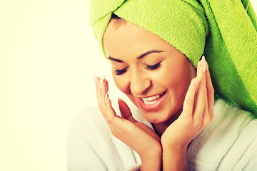 Woman in bathrobe touching face