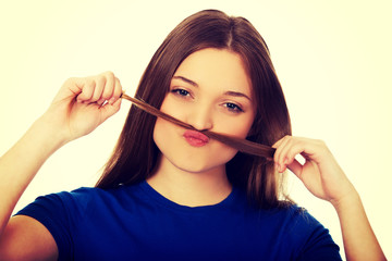 Teenager making moustache from hair.