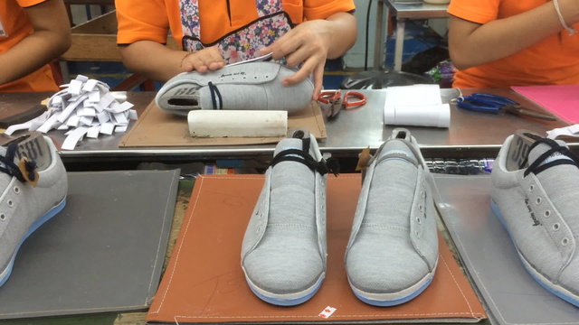 worker making shoe in footwear production line