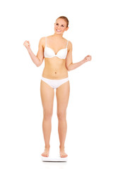 Fototapeta premium Happy woman standing on scales