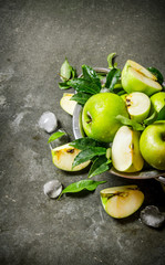 Green apples in a Cup with ice .