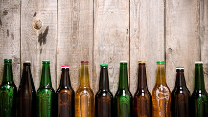Beer bottles on wooden table .