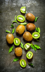 Kiwi with leaves . On the stone table .