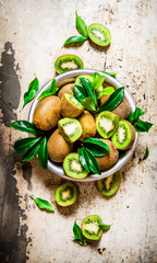 Fresh kiwi fruit in a cup with leaves.