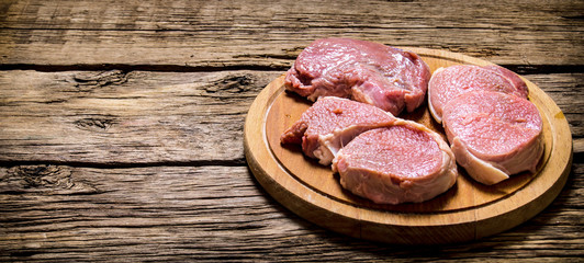 Fresh steaks on an old wooden Board.