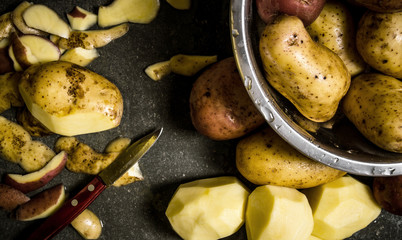 The concept of wet peeled potatoes on the stone table .
