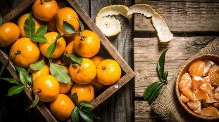 box with whole mandarins, leaves, and spooned in a Cup.