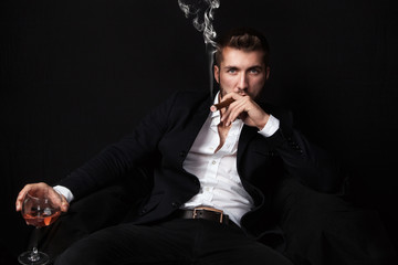 Geschäftsmann entspannt bei Zigarre und Drink 
