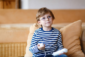 Little kid boy playing video game console 