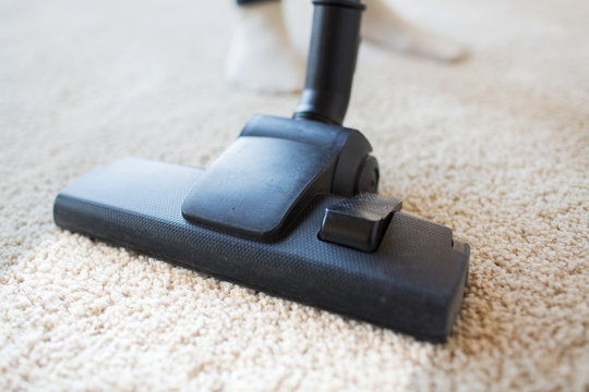 Close Up Of Vacuum Cleaner Cleaning Carpet At Home