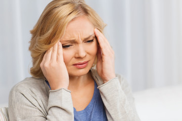 unhappy woman suffering from headache at home