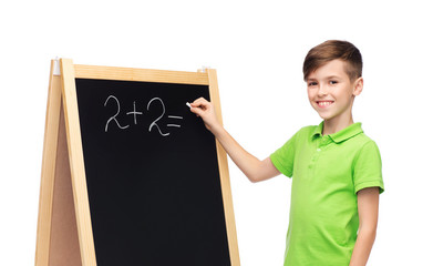 happy boy solving math on school blackboard