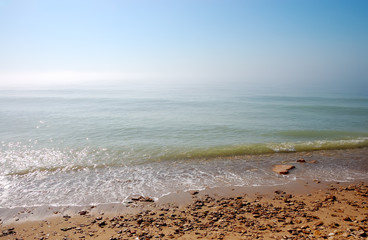 Morning sea shore and the horizon in a haze