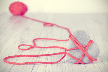 Retro toned wooden heart tied with red yarn, concept picture