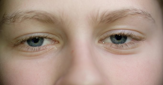 4K the eyes of a child 11-12 years blue extreme close up, blinking slow motion