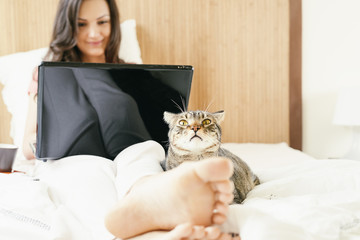 Woman working with her laptop computer and having breakfast.