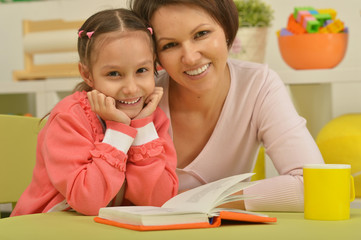 Daughter and mother reading the book